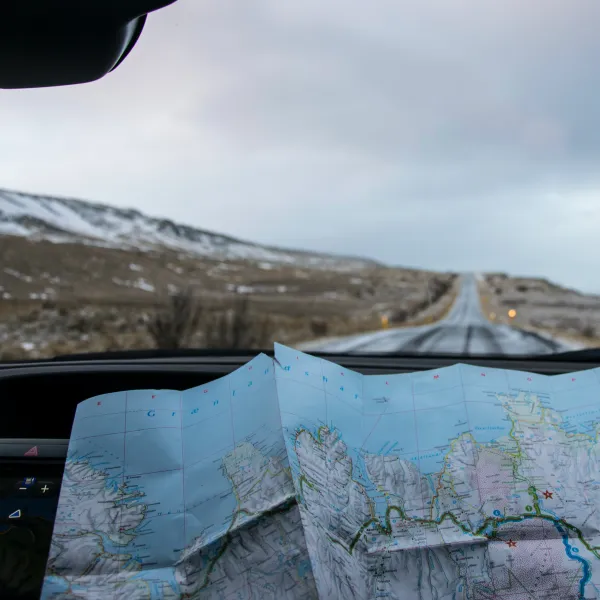 a driver studies a map inside of a car