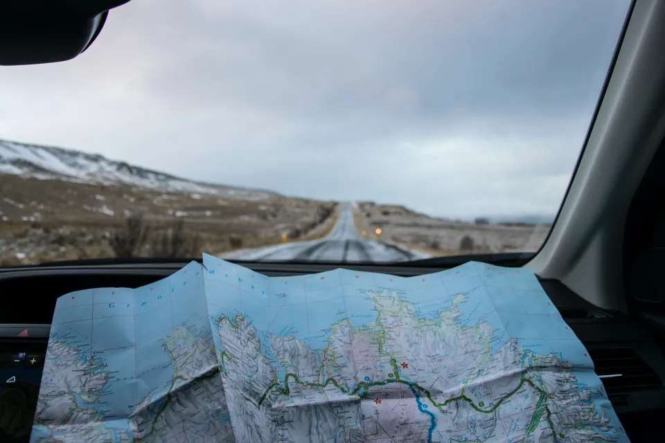 a driver studies a map inside of a car